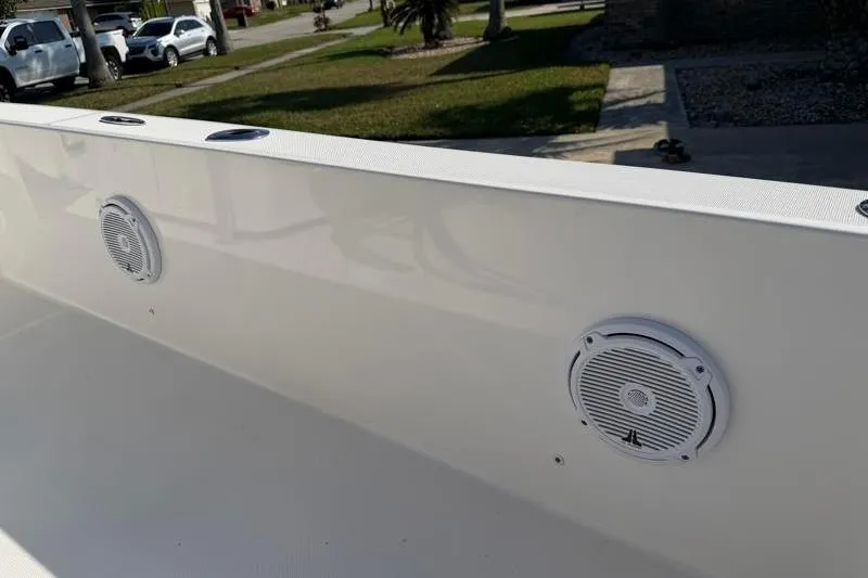 Slide: The Image of 2012 Edgewater 240 Inshore boat interior with built-in speakers and sleek white finish. - 71