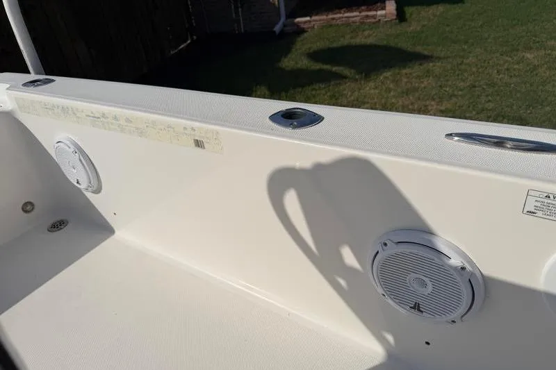 Slide: The Image of Interior view of a 2012 Edgewater 240 Inshore boat, featuring speakers and rod holders. - 72