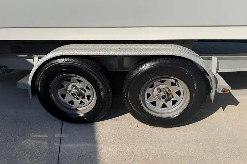 Slide: The Image of Trailer wheels of a 2012 Edgewater 240 Inshore boat on pavement. - 80