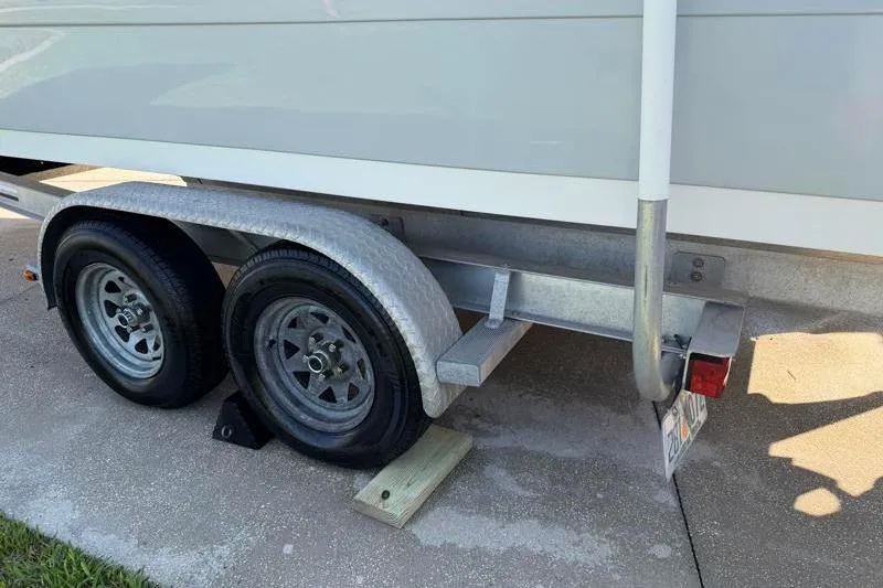 Slide: The Image of Trailer of 2012 Edgewater 240 Inshore boat with dual wheels on pavement. - 81