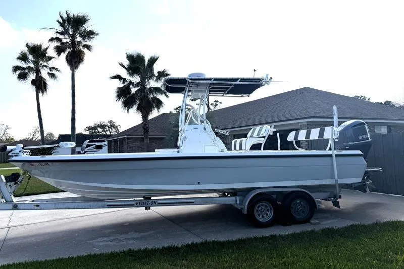 Slide: The Image of 2012 Edgewater 240 Inshore boat on trailer, parked in driveway with palm trees. - 9