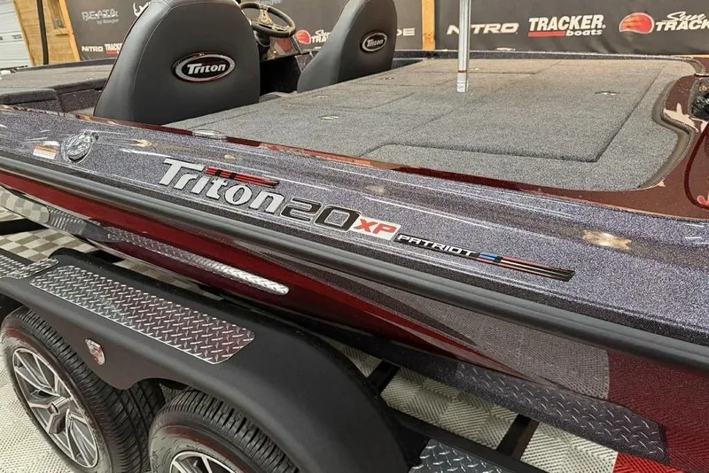 Slide: The Image of 2026 Triton 20XP Patriot boat with sleek design and logo detailing. - 14
