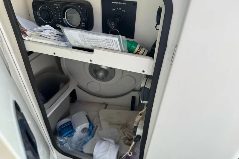 Slide: The Image of Interior storage compartment of a 2012 Sea Ray 240 Sundeck boat with various items. - 18