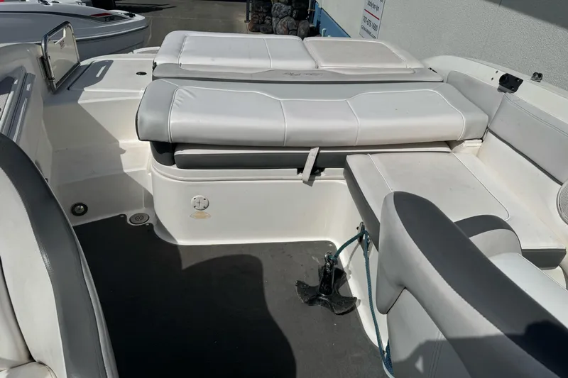 Slide: The Image of 2012 Sea Ray 240 Sundeck interior with white cushioned seating and storage compartments. - 6
