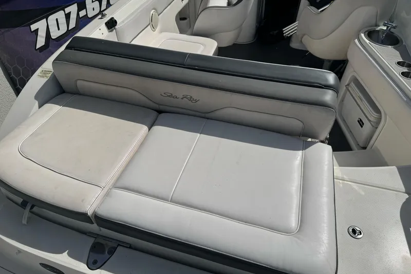 Slide: The Image of 2012 Sea Ray 240 Sundeck interior with cushioned seating and cup holders. - 8