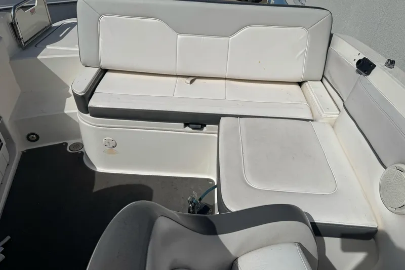 Slide: The Image of 2012 Sea Ray 240 Sundeck interior seating with white upholstery and gray accents. - 9