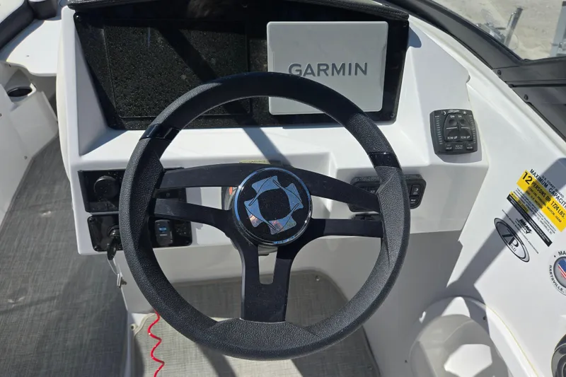 Slide: The Image of 2026 Stingray 231 DC boat dashboard with Garmin navigation system and steering wheel. - 11