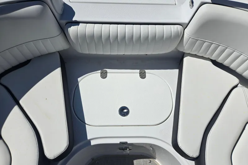 Slide: The Image of 2026 Stingray 231 DC boat interior with white cushioned seating and storage compartment. - 8