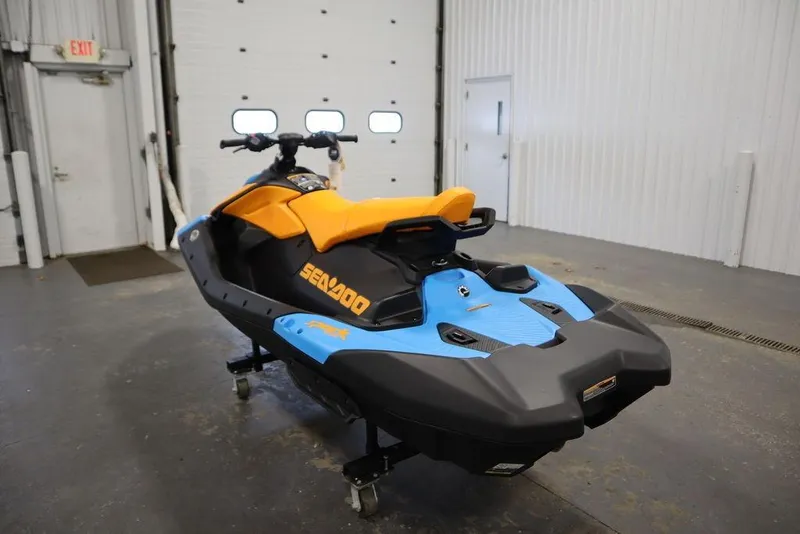 Slide: The Image of 2026 Sea-Doo Spark Trixx for 3 in a garage, featuring vibrant orange and blue colors. - 4