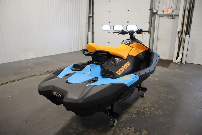 Slide: The Image of 2026 Sea-Doo Spark Trixx for 3 in a garage, showcasing vibrant blue and orange design. - 5