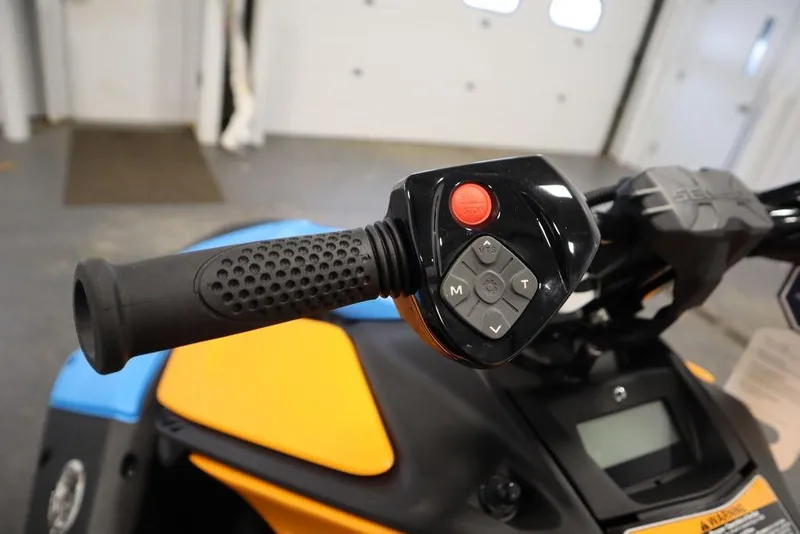 Slide: The Image of 2026 Sea-Doo Spark Trixx handlebar controls with vibrant orange and blue accents. - 9