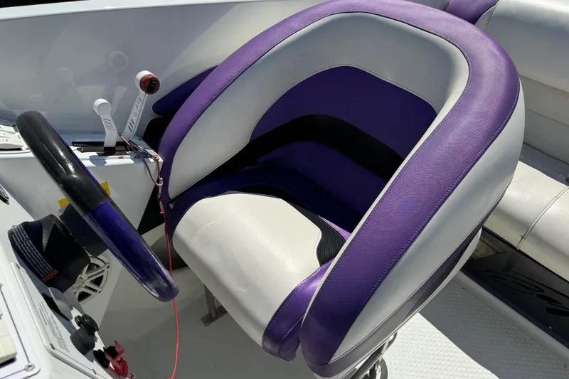 Slide: The Image of Purple and white cockpit seat of a 1999 Baja 25 Outlaw boat. - 13