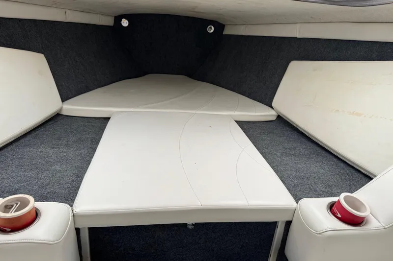 Slide: The Image of Interior cabin of a 1999 Baja 25 Outlaw boat with white seating and cup holders. - 22