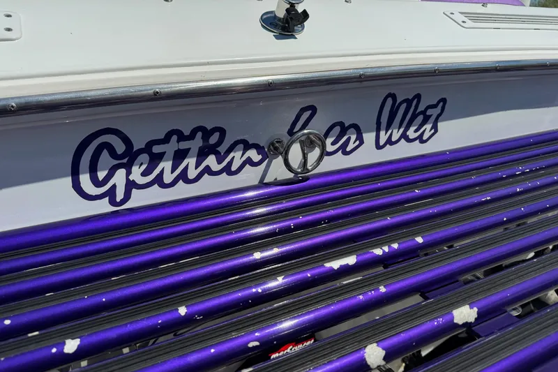Slide: The Image of 1999 Baja 25 Outlaw boat with "Gettin' Sea Wet" lettering and purple accents. - 3
