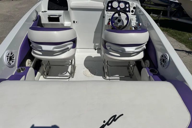 Slide: The Image of Interior of a 1999 Baja 25 Outlaw boat with purple and white seating. - 7