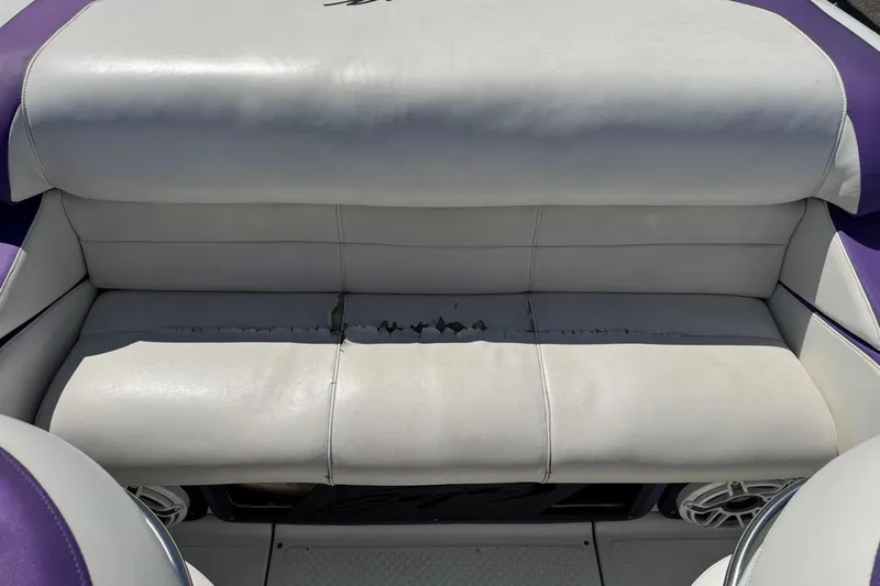 Slide: The Image of 1999 Baja 25 Outlaw boat seat with visible wear and tear on white upholstery. - 8