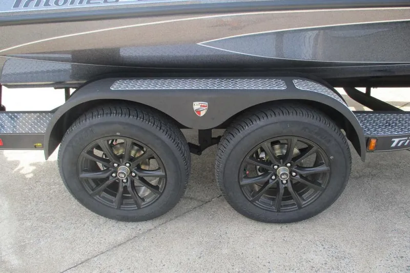 Slide: The Image of Trailer wheels of 2026 Triton 20XP Patriot with black rims and diamond plate fenders. - 12