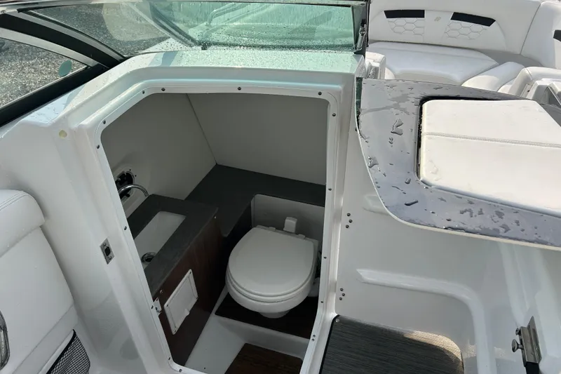 Slide: The Image of 2023 Four Winns HD8 OB boat interior with compact bathroom and toilet. - 13