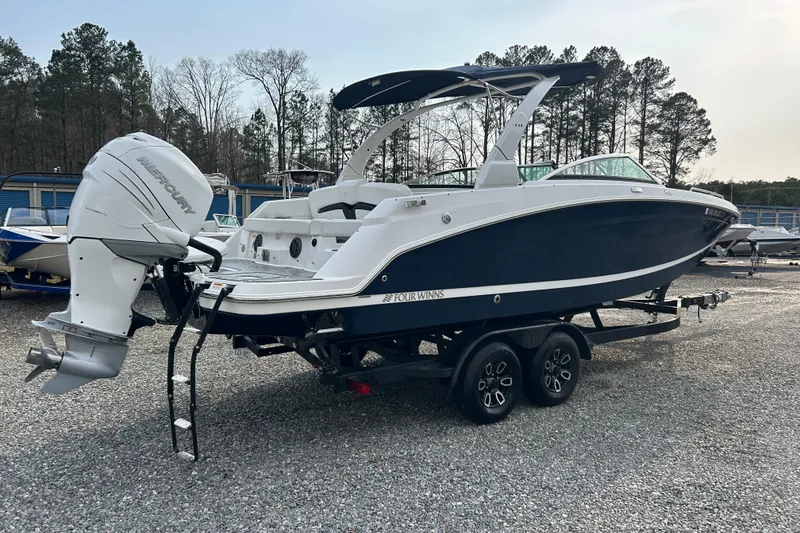 Slide: The Image of 2023 Four Winns HD8 OB boat with Mercury outboard engine on a trailer. - 2