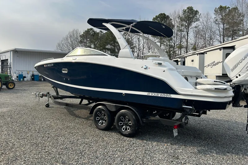 Slide: The Image of 2023 Four Winns HD8 OB boat on trailer, parked outdoors. - 4