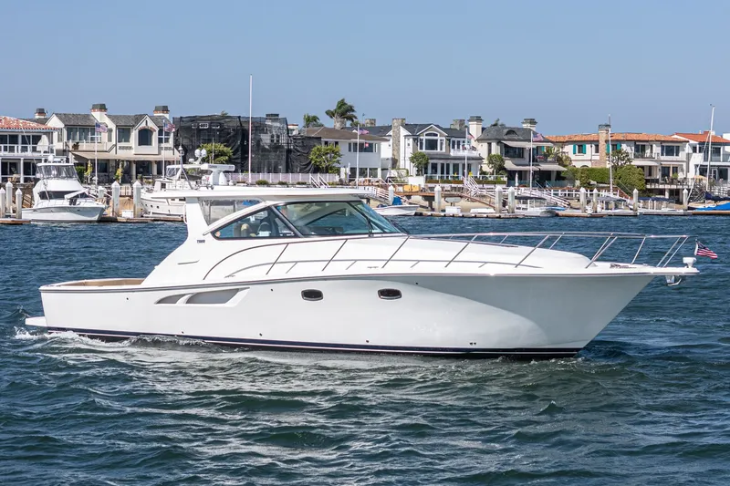Slide: The Image of 2018 Tiara Yachts 43 Open on water near coastal homes. - 2