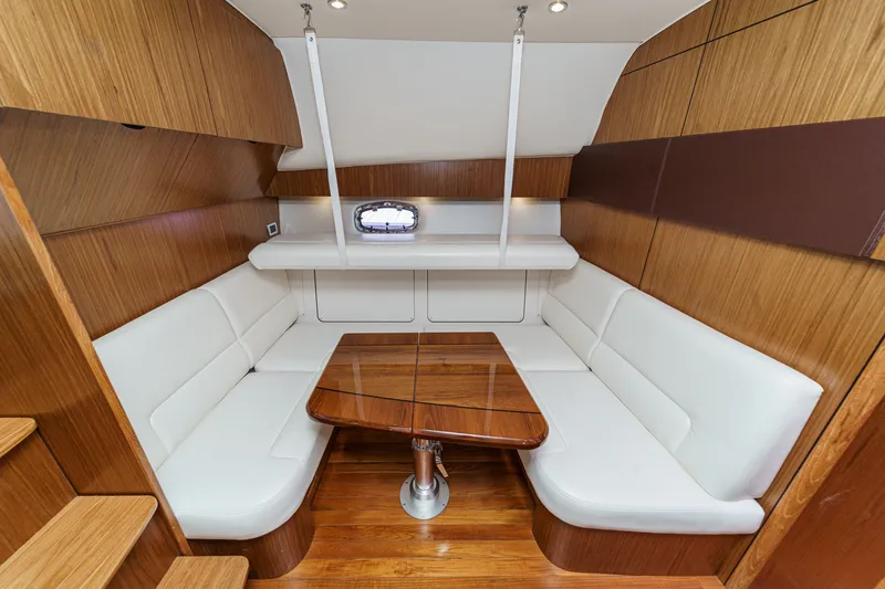 Slide: The Image of Interior of 2018 Tiara Yachts 43 Open with wood table and white seating. - 36