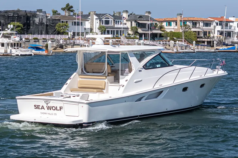 Slide: The Image of 2018 Tiara Yachts 43 Open on water near coastal homes. - 6