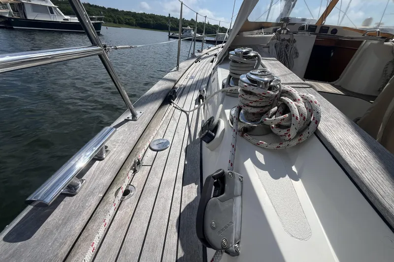 Slide: The Image of 2017 Rustler 37 sailboat deck with winches and ropes, docked on calm water. - 13
