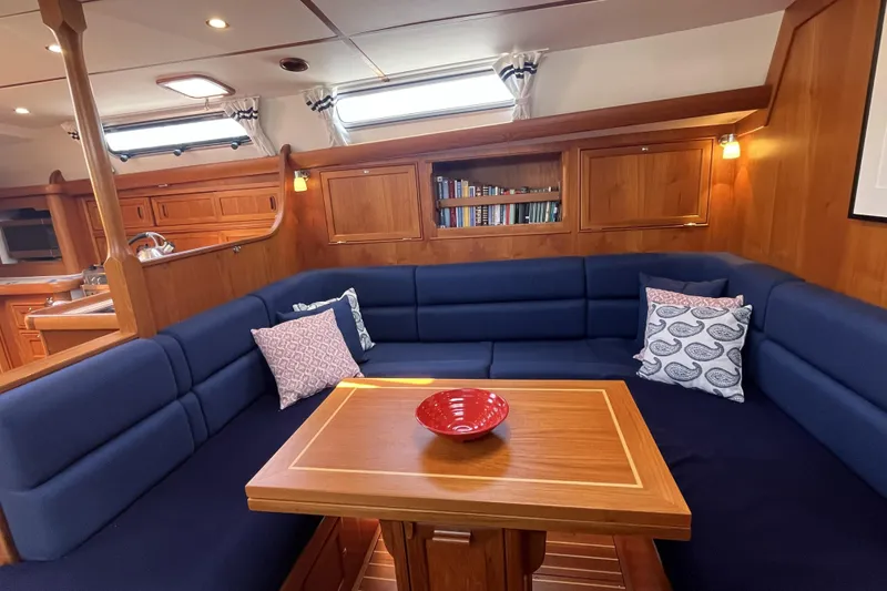Slide: The Image of Luxurious 2017 Rustler 37 yacht interior with blue seating, wooden table, and bookshelves. - 21