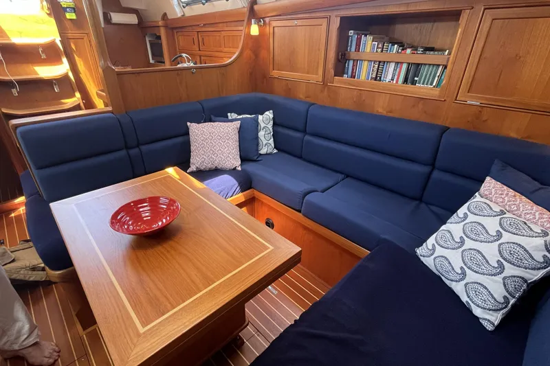 Slide: The Image of Luxurious 2017 Rustler 37 yacht interior with blue seating, wooden table, and bookshelves. - 22