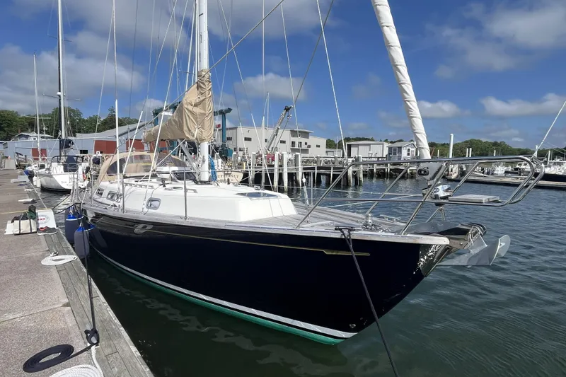 Slide: The Image of 2017 Rustler 37 sailboat docked at a marina under a clear blue sky. - 3