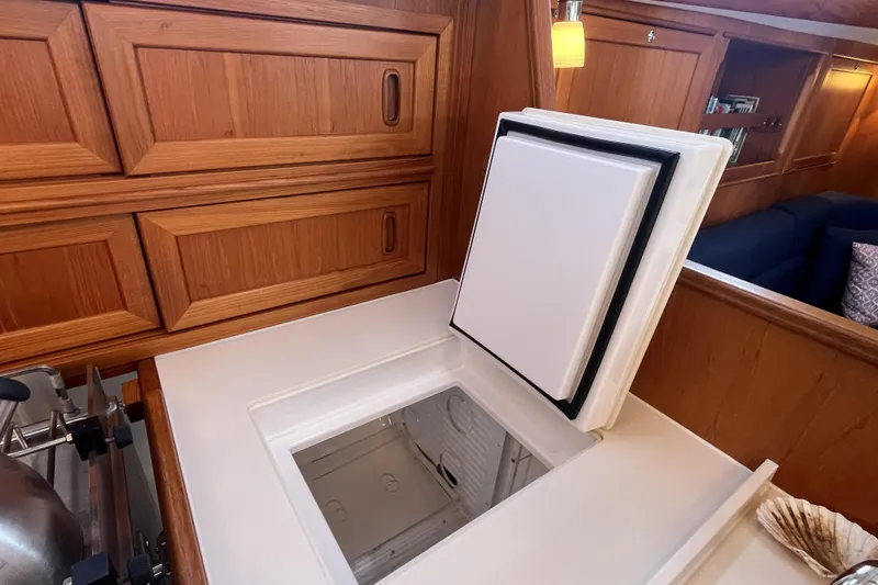 Slide: The Image of Interior of 2017 Rustler 37 yacht featuring wooden cabinetry and built-in refrigerator. - 33