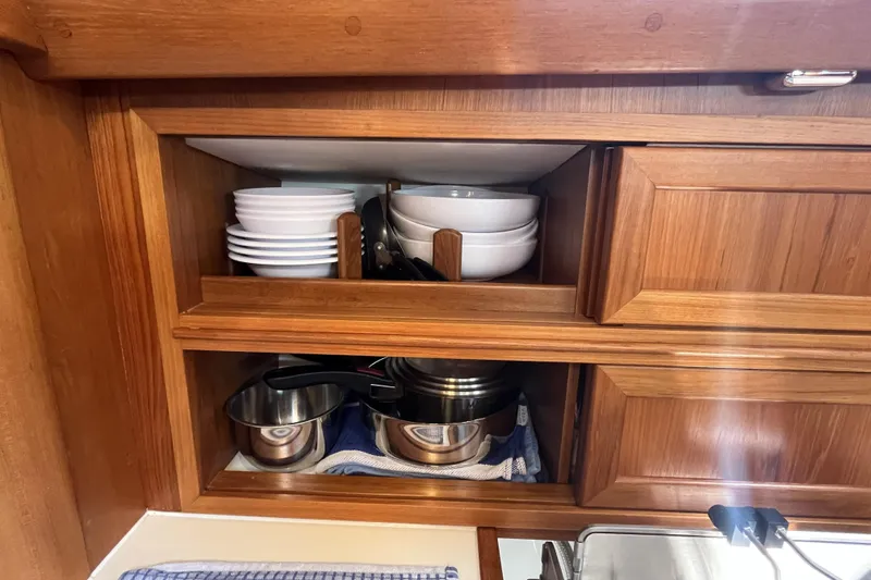 Slide: The Image of Wooden cabinet in a 2017 Rustler 37 yacht, storing dishes and cookware. - 35
