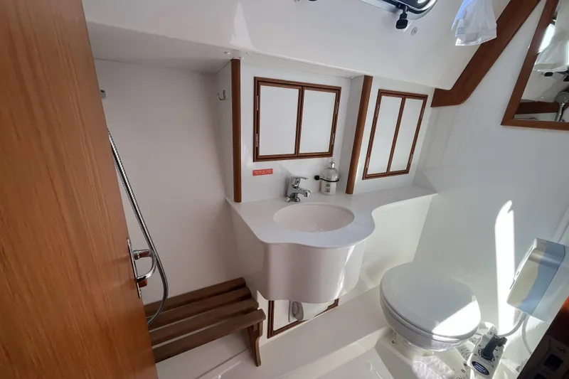 Slide: The Image of 2017 Rustler 37 yacht bathroom with sink, toilet, and wooden accents. - 43