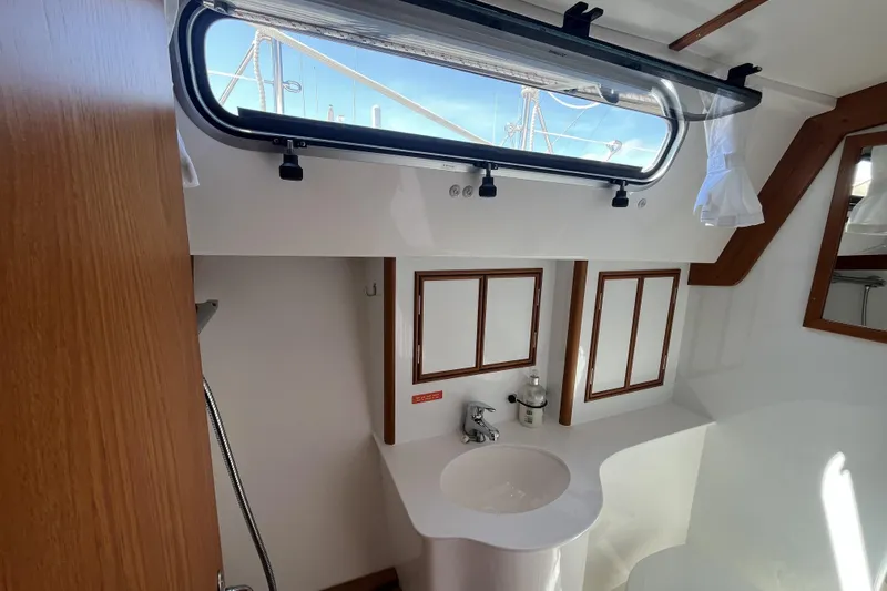 Slide: The Image of Interior of 2017 Rustler 37 yacht bathroom with sink, window, and wooden accents. - 44