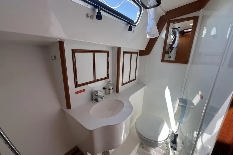 Slide: The Image of Bathroom interior of a 2017 Rustler 37 yacht, featuring sink, toilet, and wooden accents. - 45
