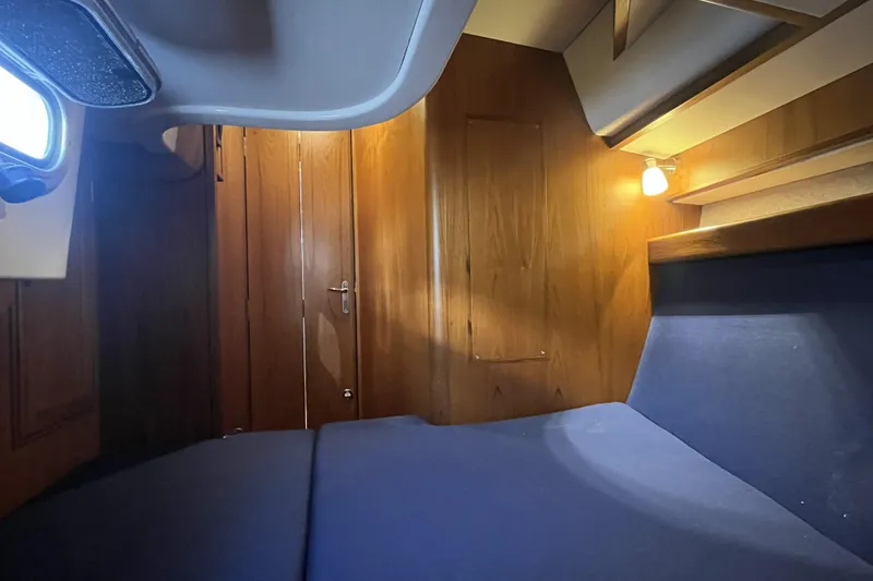 Slide: The Image of Cozy cabin interior of a 2017 Rustler 37 yacht with wooden paneling and blue upholstery. - 48