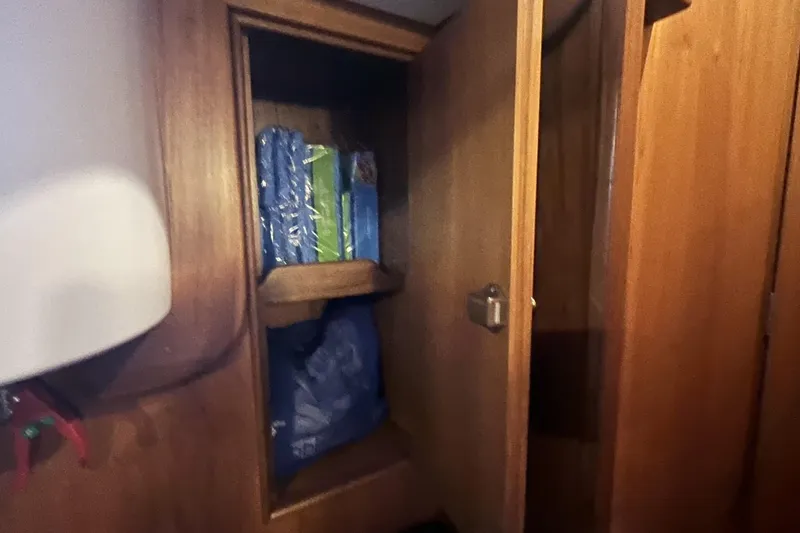 Slide: The Image of Wooden storage cabinet inside 2017 Rustler 37 yacht, containing blue and green items. - 49