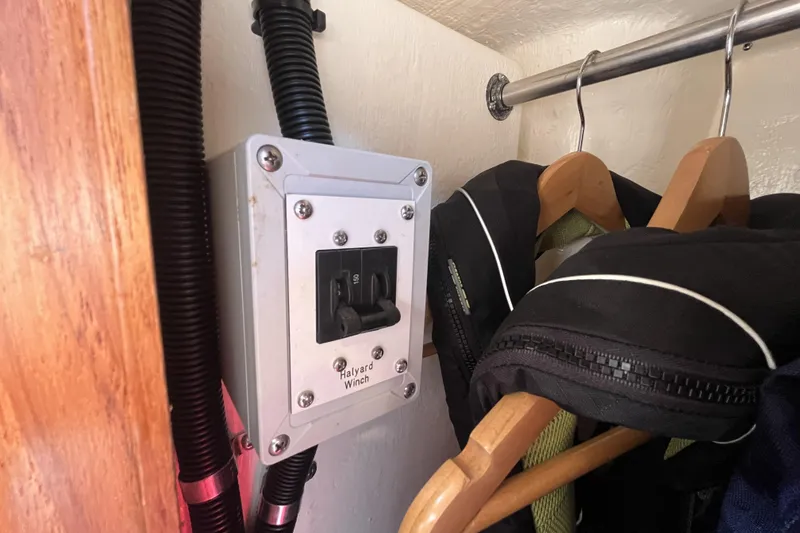 Slide: The Image of Halyard winch switch in a 2017 Rustler 37 yacht closet with hanging jackets. - 53