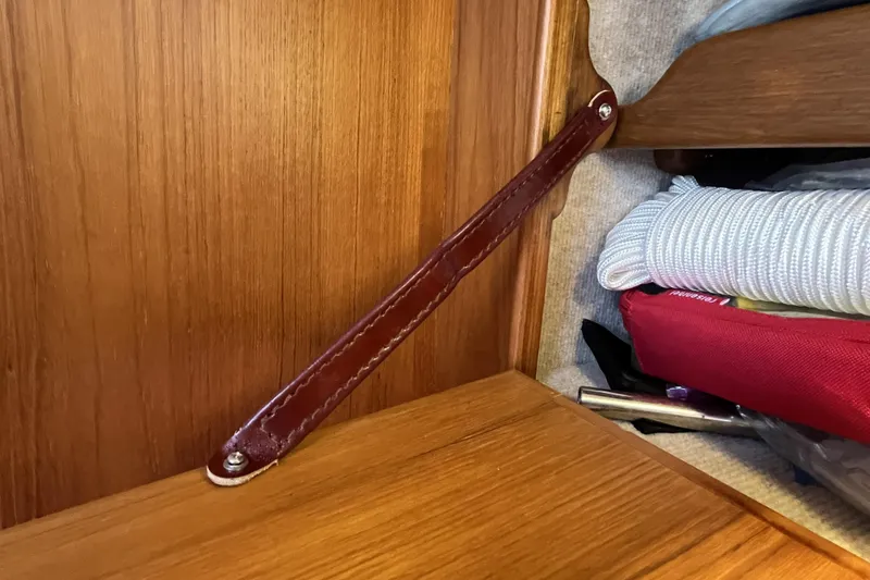 Slide: The Image of Wooden interior detail of a 2017 Rustler 37 yacht with leather strap and storage items. - 54