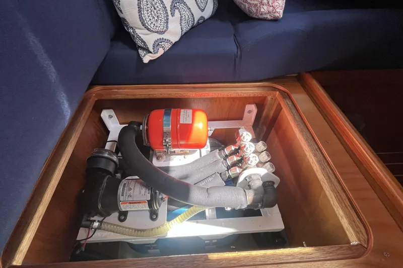 Slide: The Image of Engine compartment of a 2017 Rustler 37 yacht, featuring mechanical components and seating area. - 58