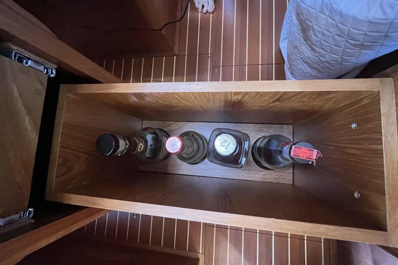 Slide: The Image of Wooden storage compartment on a 2017 Rustler 37 yacht, holding four bottles. - 59
