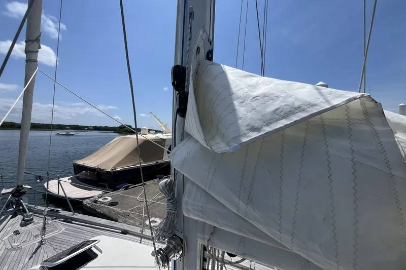 Slide: The Image of Sailboat Rustler 37 (2017) docked, with sails partially unfurled under a clear blue sky. - 71
