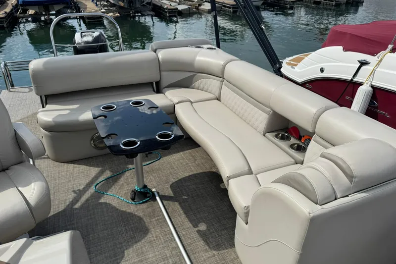 Slide: The Image of 2017 Harris FloteBote 240 Sunliner interior with plush seating and cupholders on a docked boat. - 7