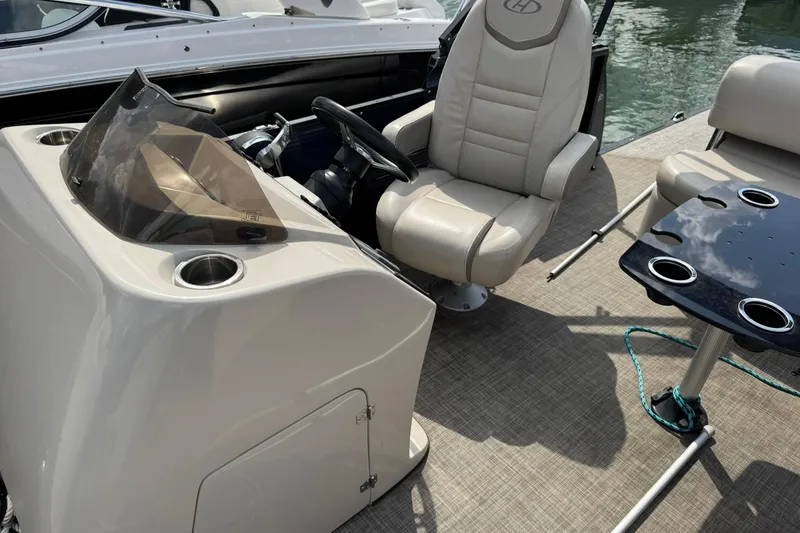 Slide: The Image of 2017 Harris FloteBote 240 Sunliner interior with captain's chair and table on water. - 8