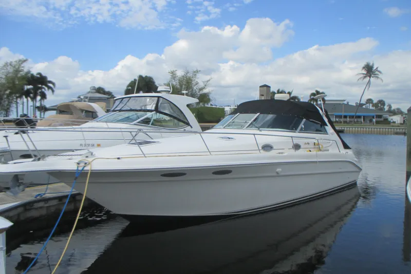 The Image of 1997 Sea Ray Sundancer 330 yacht docked in a marina under a partly cloudy sky. - 0