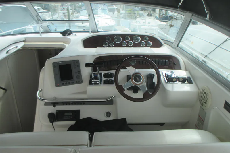 Slide: The Image of 1997 Sea Ray Sundancer 330 helm with steering wheel and navigation controls. - 11