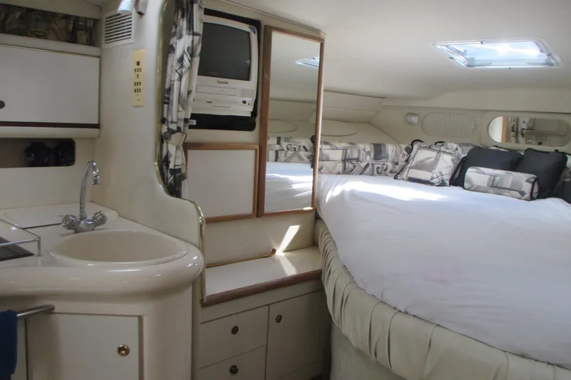 Slide: The Image of 1997 Sea Ray Sundancer 330 cabin interior with bed, sink, and TV. - 16