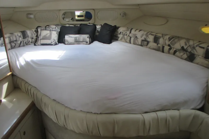 Slide: The Image of 1997 Sea Ray Sundancer 330 cabin interior with a spacious bed and decorative pillows. - 17