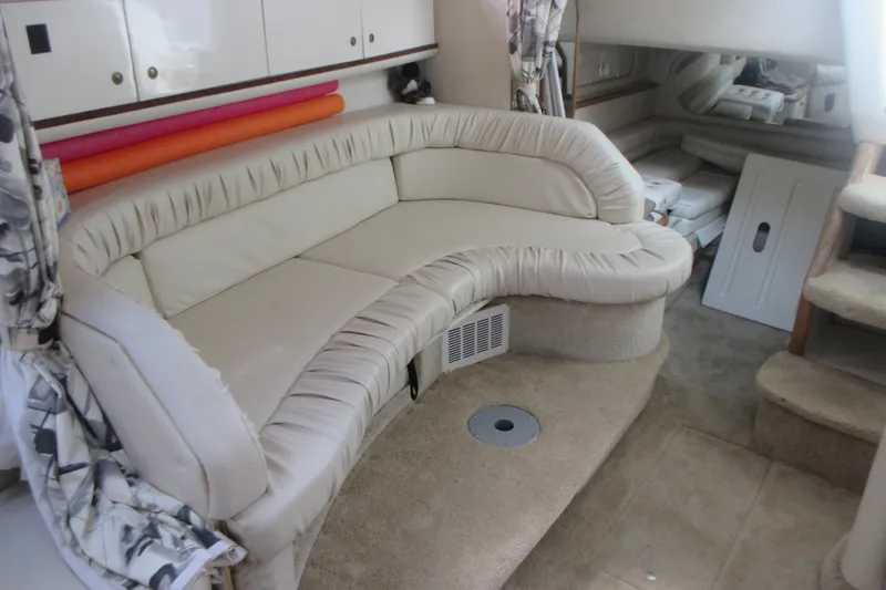 Slide: The Image of 1997 Sea Ray Sundancer 330 interior with curved beige seating and carpeted flooring. - 18